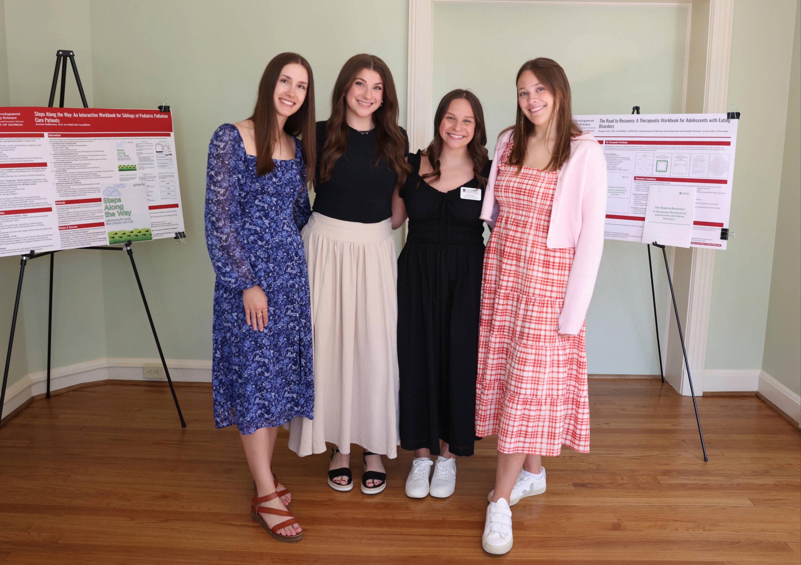 Four child life students standing by two research posters