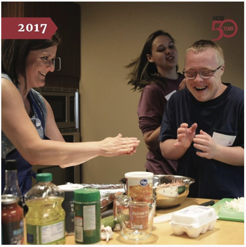 Image of some students cooking in the kitchen and laughing.